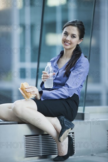 Caucasian businesswoman eating lunch