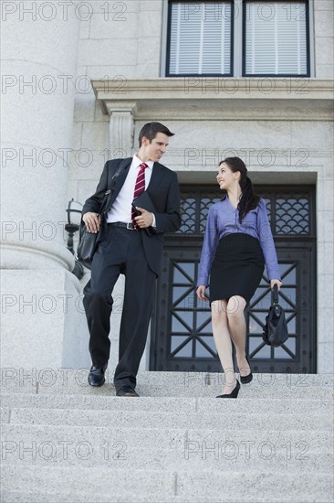 Caucasian business people walking down stairs