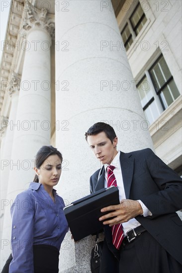 Caucasian business people looking at digital tablet