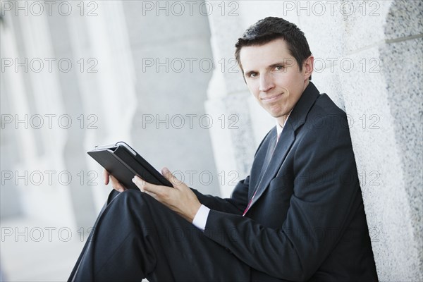 Caucasian businessman using digital tablet outdoors