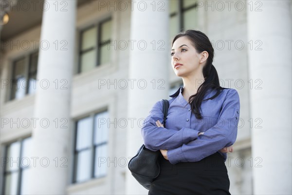 Caucasian businesswoman standing outdoors with arms crossed