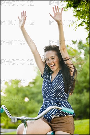 Cheering Caucasian woman cheering on bicycle