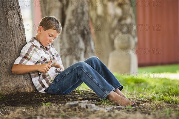 Caucasian boy whittling stick