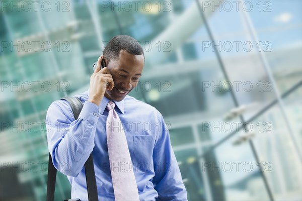 Black businessman talking on cell phone outdoors