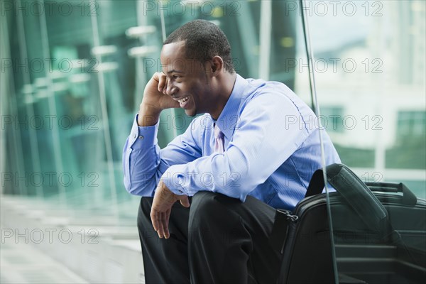 Black businessman talking on cell phone outdoors