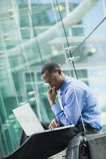 Black businessman using laptop outdoors