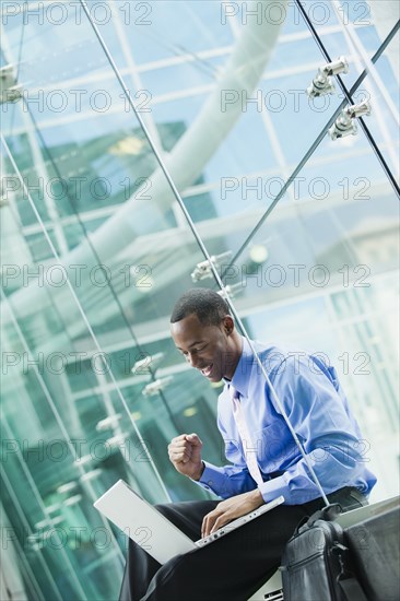 Black businessman using laptop outdoors