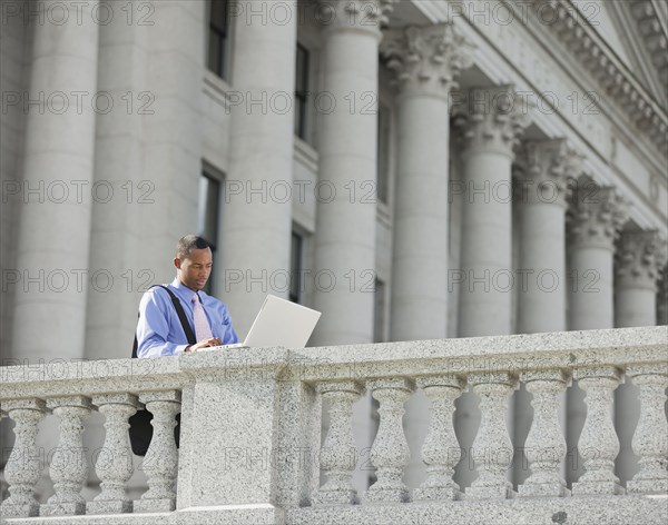 Black businessman using laptop outdoors
