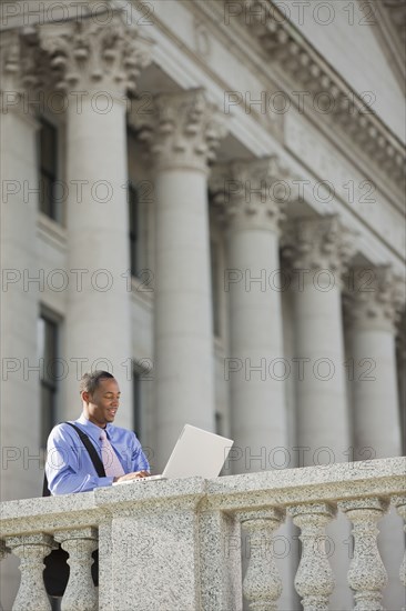 Black businessman using laptop outdoors