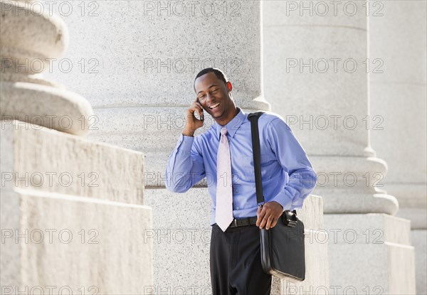 Black businessman talking on cell phone outdoors