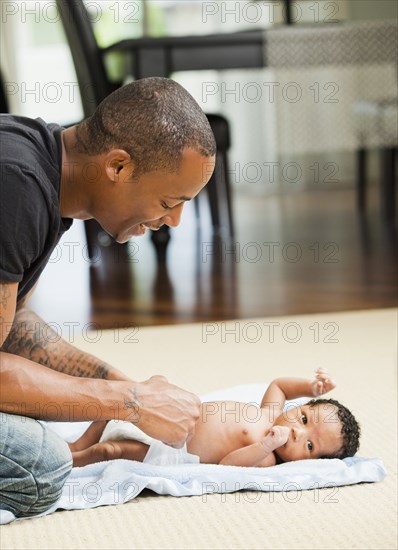 Father changing newborn baby's diaper