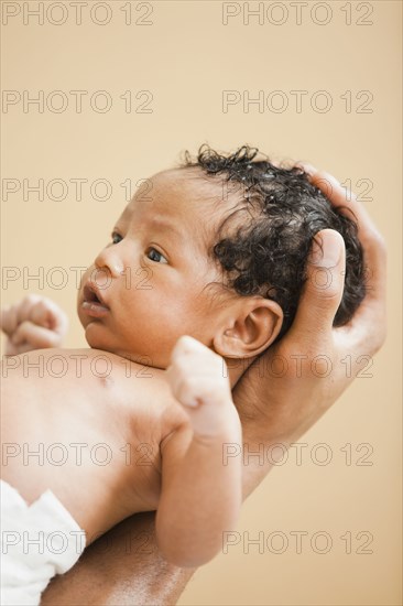 Father cradling newborn baby in hand