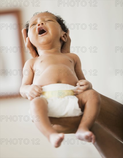 Father cradling newborn baby in hands