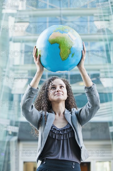 Caucasian businesswoman lifting globe