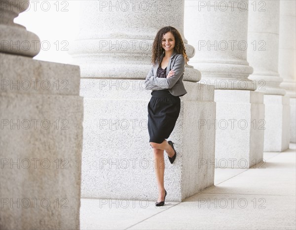 Caucasian businesswoman leaning against pillar outdoors