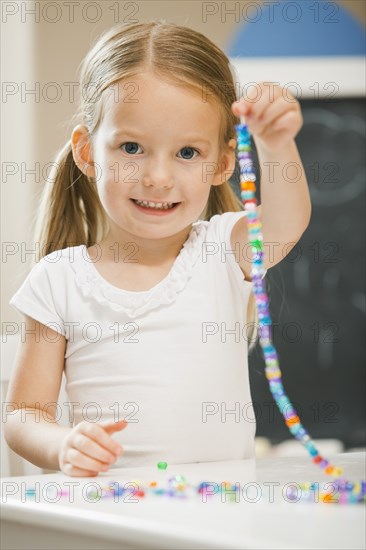 Caucasian girl stringing beads