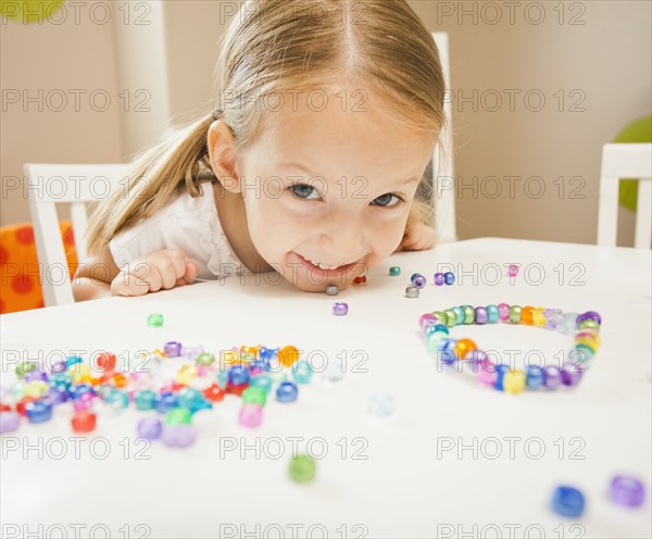 Caucasian girl stringing beads