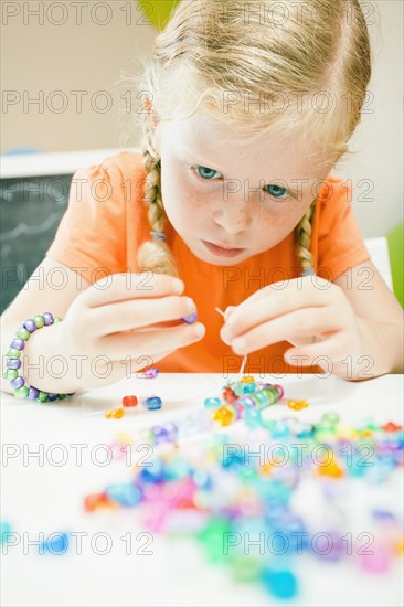 Caucasian girl stringing beads