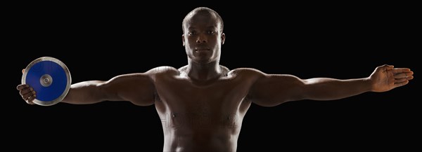 African American man holding track and field discus