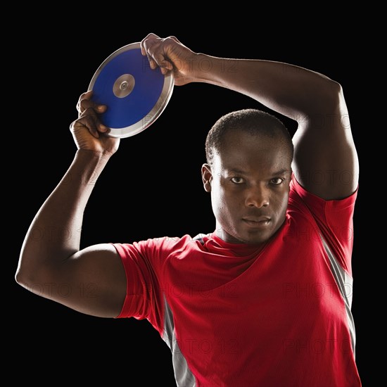 African American man holding track and field discus