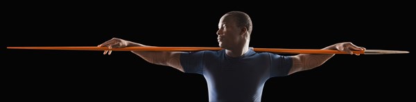 African American man holding track and field javelin