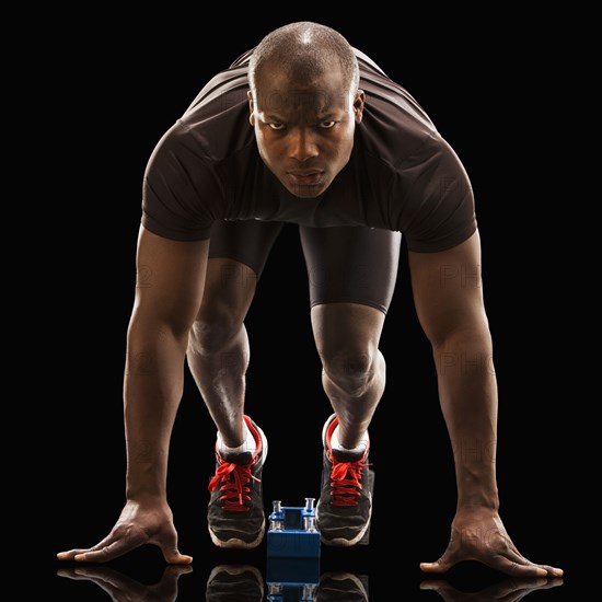 African American runner crouching at starting block