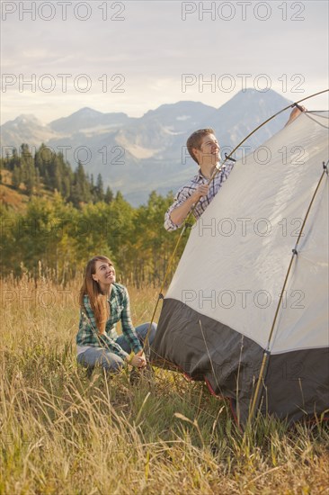 Caucasian couple setting up tent