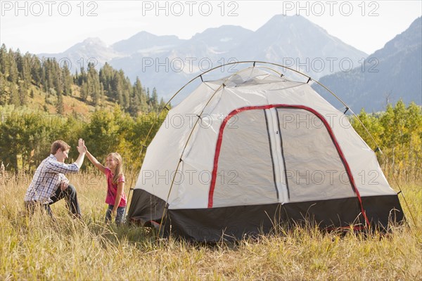 Caucasian father and daughter setting up tent