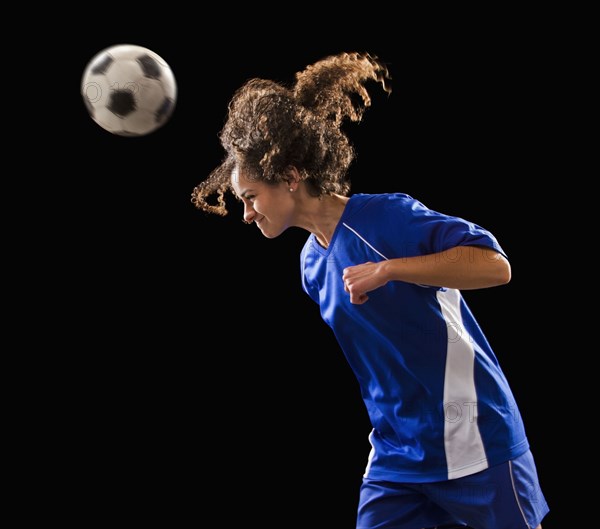 Caucasian soccer player heading the ball