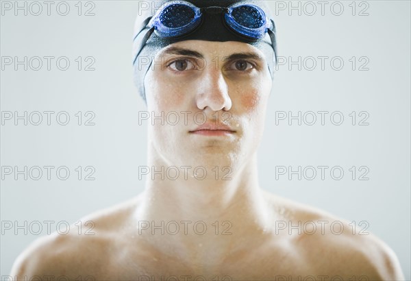 Caucasian teenage boy in swim cap and goggles