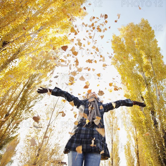 Caucasian woman playing with autumn leaves