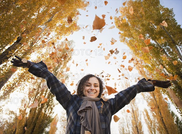 Caucasian woman playing with autumn leaves