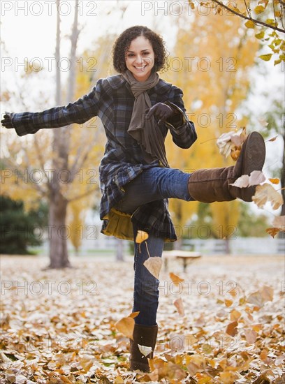 Caucasian woman playing with autumn leaves