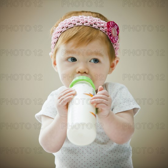 Caucasian baby girl drinking bottle