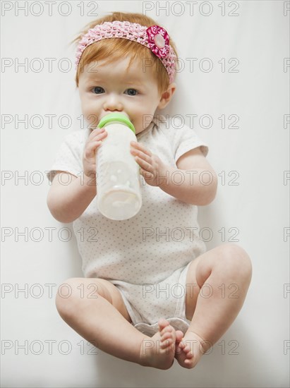 Caucasian baby girl drinking bottle