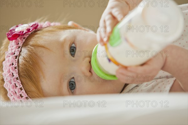 Caucasian baby girl drinking bottle