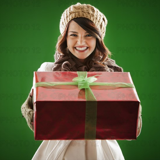 Mixed race woman holding Christmas gift