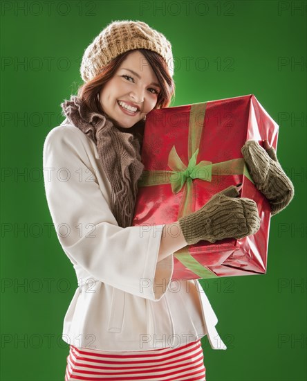 Mixed race woman holding Christmas gift