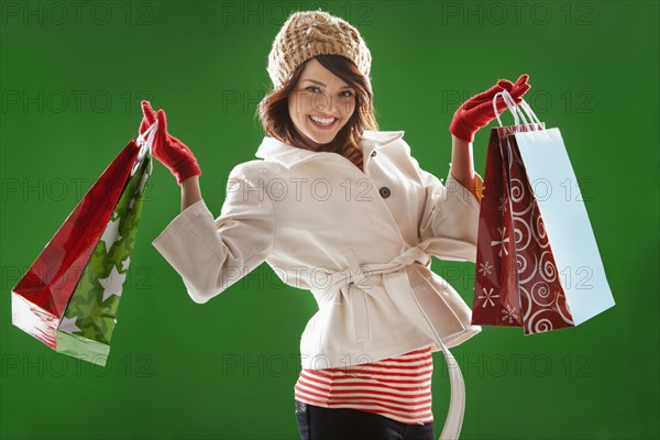 Mixed race woman holding Christmas shopping bags