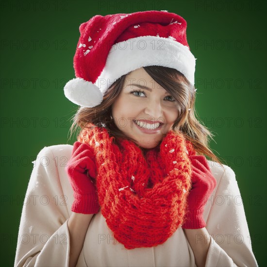 Mixed race woman wearing scarf and Santa hat