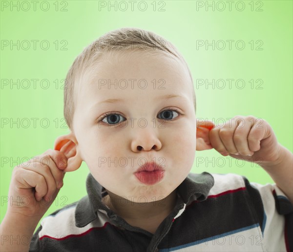 Caucasian boy pulling his ears