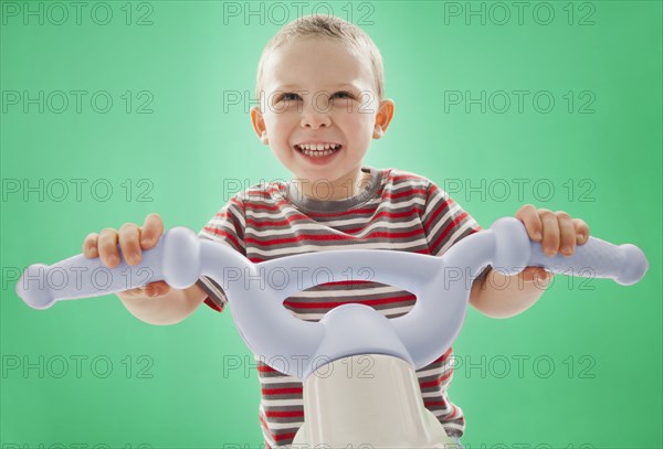 Caucasian boy riding plastic bicycle