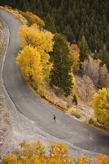 Caucasian woman running along autumn road