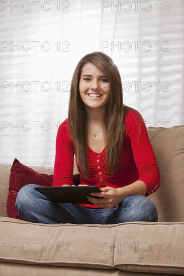 Caucasian woman using digital tablet on sofa