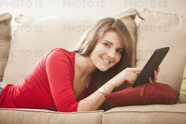 Caucasian woman using digital tablet on sofa