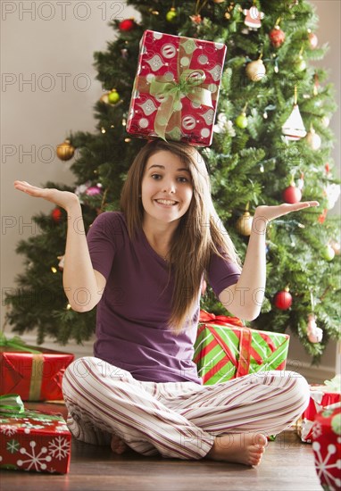 Caucasian woman balancing Christmas gift on her head