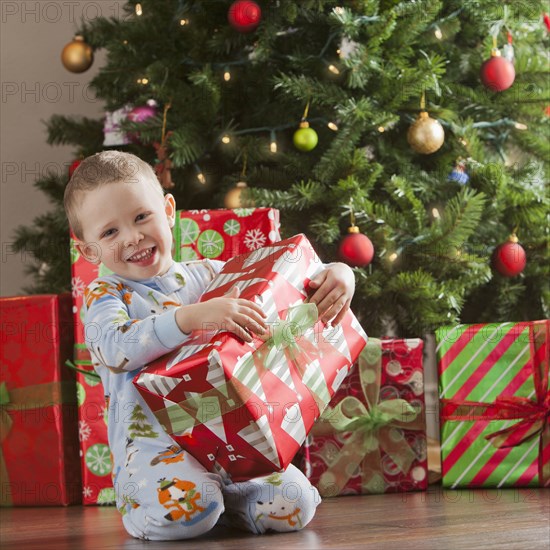 Caucasian boy holding Christmas gift