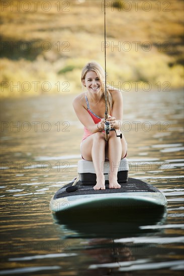 Caucasian woman fishing in lake