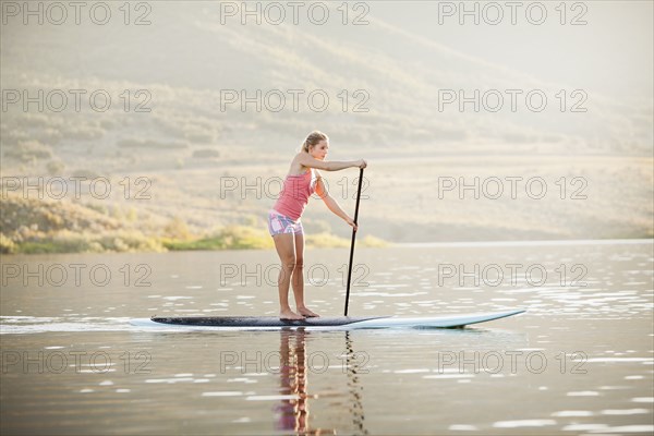 Caucasian woman on stand up paddle board