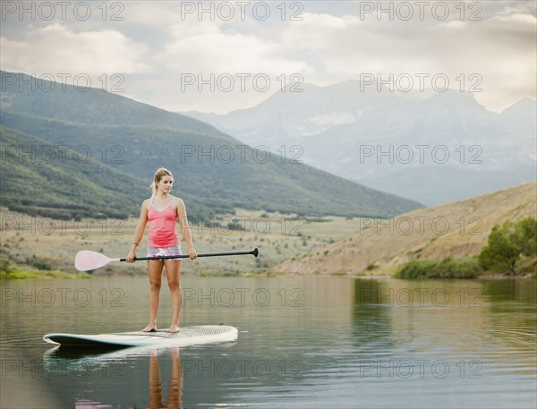 Caucasian woman on stand up paddle board